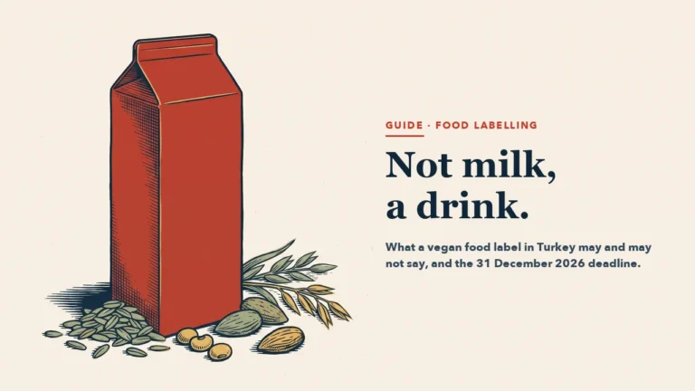 A blank red drink carton with oats, almonds and soybeans beside it
